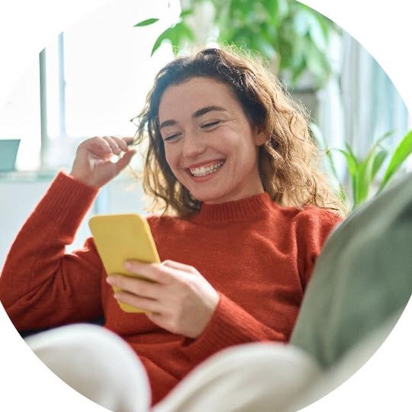 woman-smiling-looking-her-mobile